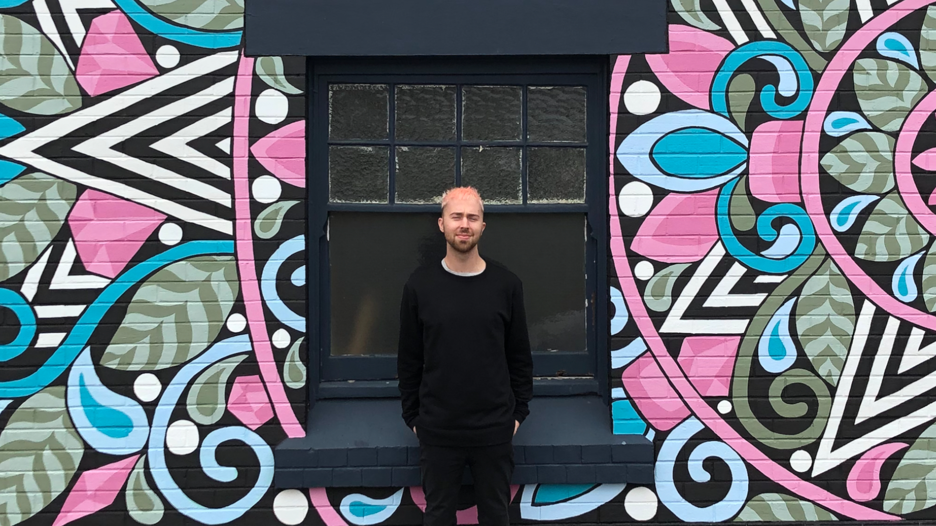 Azzurro standing in front of a mural.